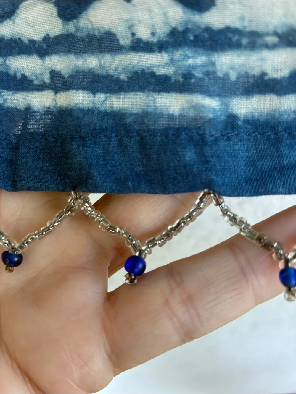 Blue & white  batik patterned short curtain or valance with beaded trim.